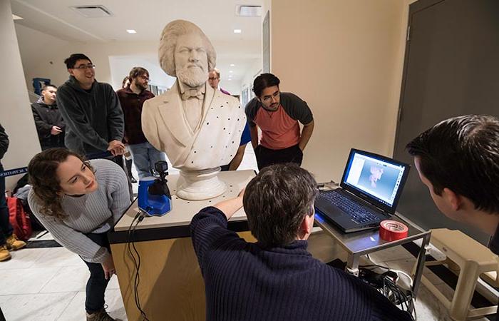 Students using technology to scan a bust of Frederick Douglass.