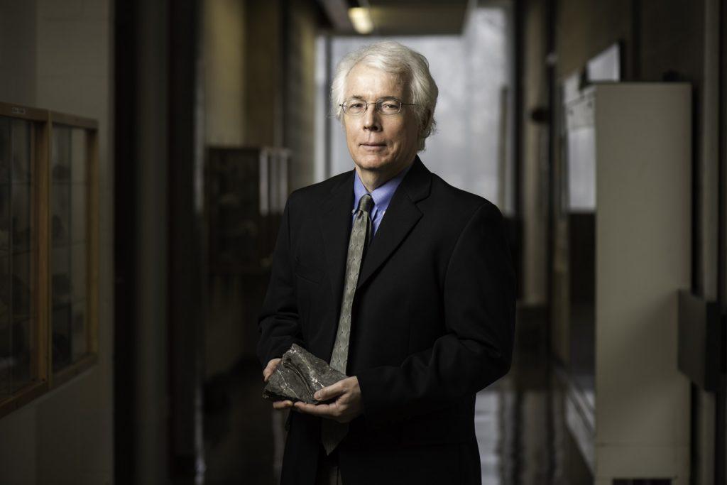 Professor John Tarduno holding a fossil as part of his research work